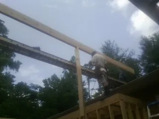 Carpenter setting a ridge beam over a new addition frame — Ice Dam Removal by Roofing Brothers in Hailey