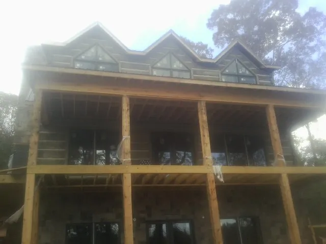 Dormers and porch framing on a large log home under construction — Roof Coating work by our crew in Hailey