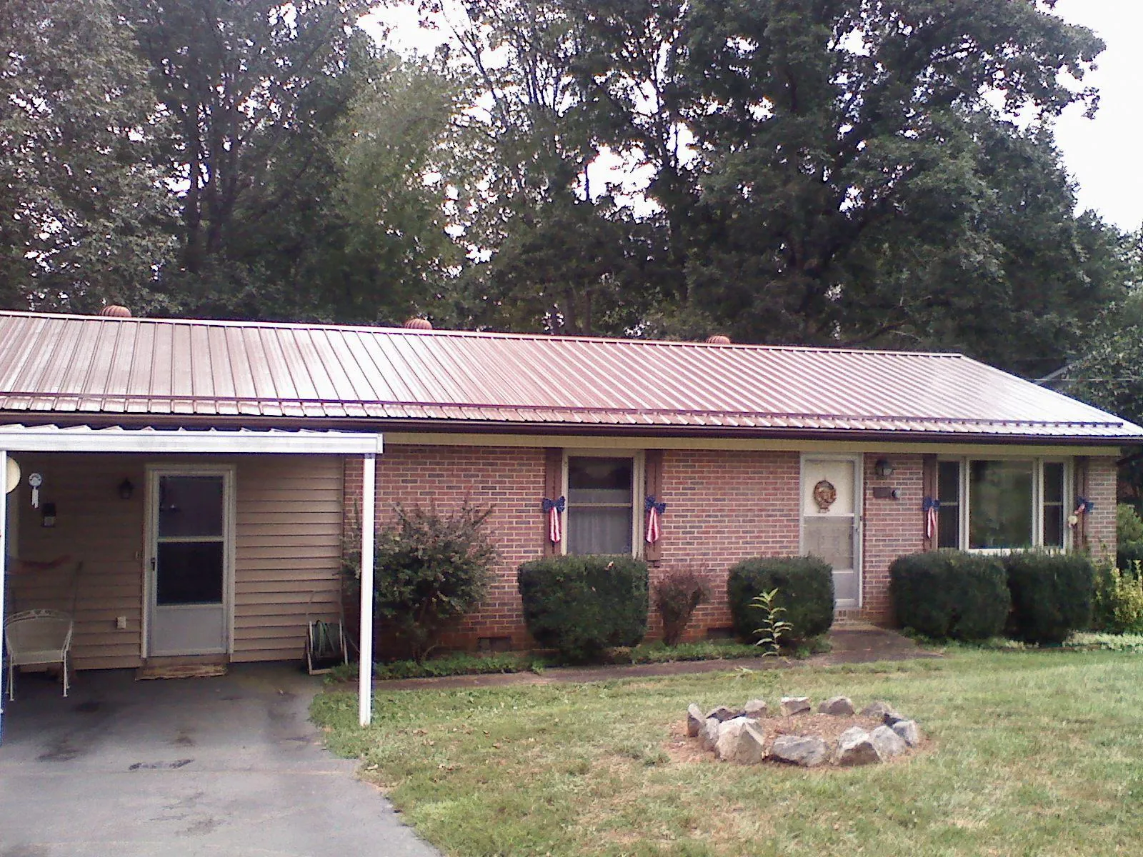 Bronze metal roof and carport on a brick ranch home — Roof Repair work by our crew in Hailey